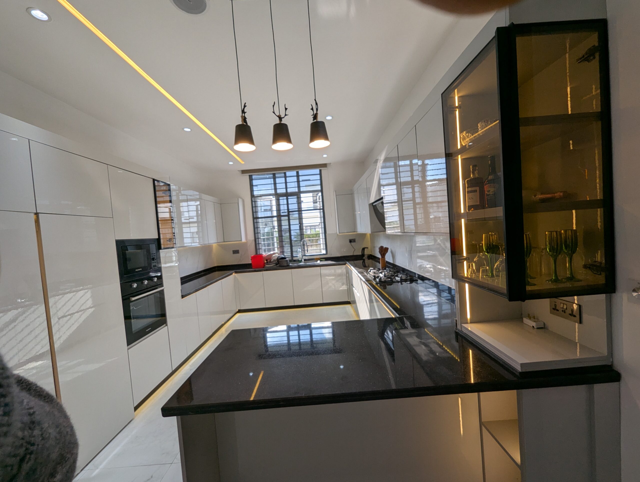 View of a modern kitchen with a seamless wood look, featuring engineered boards on the cabinets and counter surfaces.