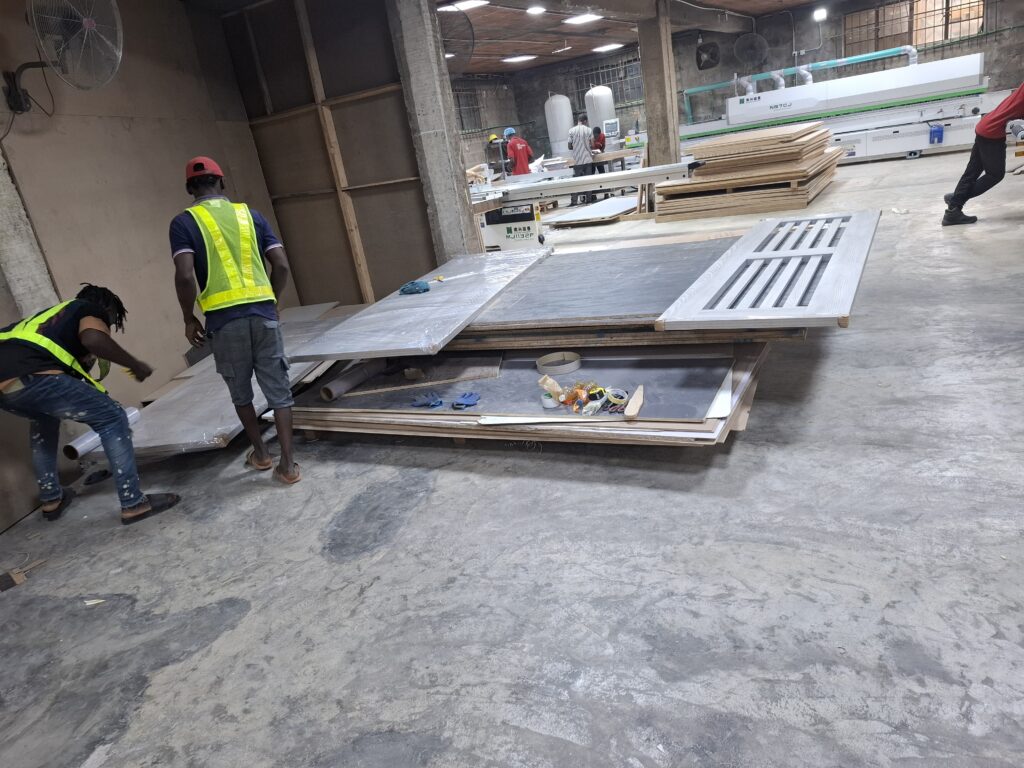 Joanswood wooden door samples laid out for inspection by staff on the factory floor.