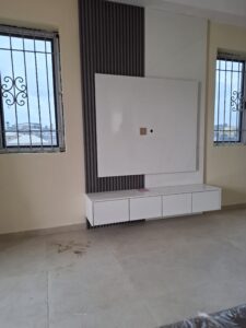 Modern wall-mounted TV unit with a white gloss back panel, grey fluted wood wall cladding, and a matching white floating media console.