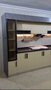 Spacious kitchen interior with wooden cabinetry, grey granite countertops, a double sink under a window, and a large chest freezer.