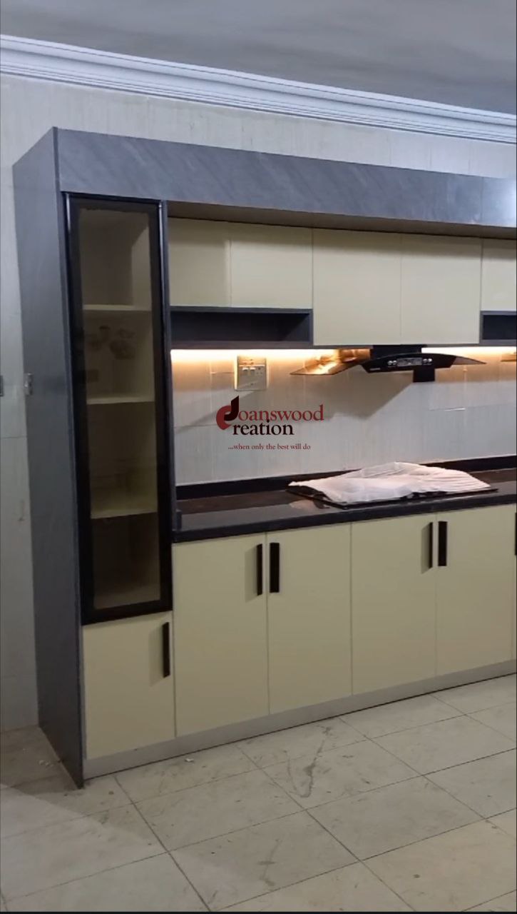 Spacious kitchen interior with wooden cabinetry, grey granite countertops, a double sink under a window, and a large chest freezer.